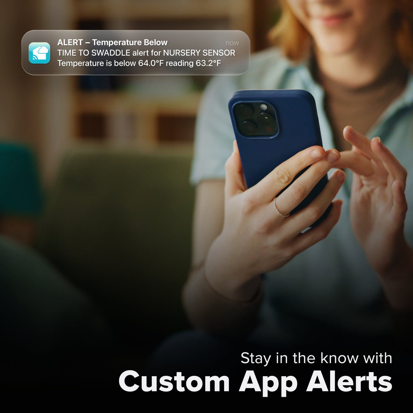 La Crosse Technology Alert and Monitoring system with a female looking at her smartphone receiving an alert for the indoor temperature dropping below set parameters of a custom alert for an interior temperature and humidity sensor with text that says stay in the know with Custom Alerts