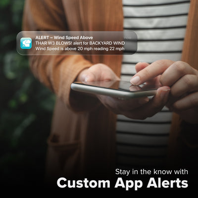 La Crosse Technology Alert and Monitoring system with someone looking at their smartphone receiving an alert for a wind sensor reaching speeds above the set parameters of a custom alert for the Glide wind speed sensor with text that says stay in the know with Custom Alerts