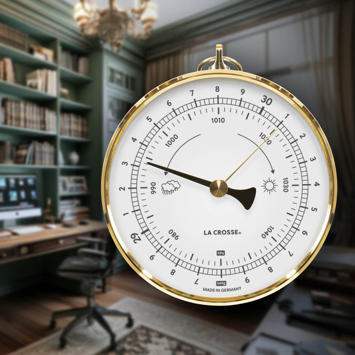 Lifestyle image of the 138-611W Analog barometer with white face, black pointer, brass indicator, and brass bezel case displayed in a home office setting, blending classic weather instrumentation with traditional décor.