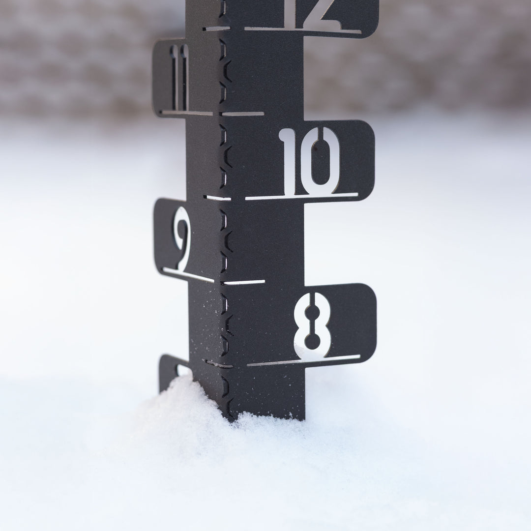 Close-up view of the 139-4686 Metal snow gauge showing seven inches of snowfall with the laser cut eight, nine, ten, eleven, and twelve inch markers in view
