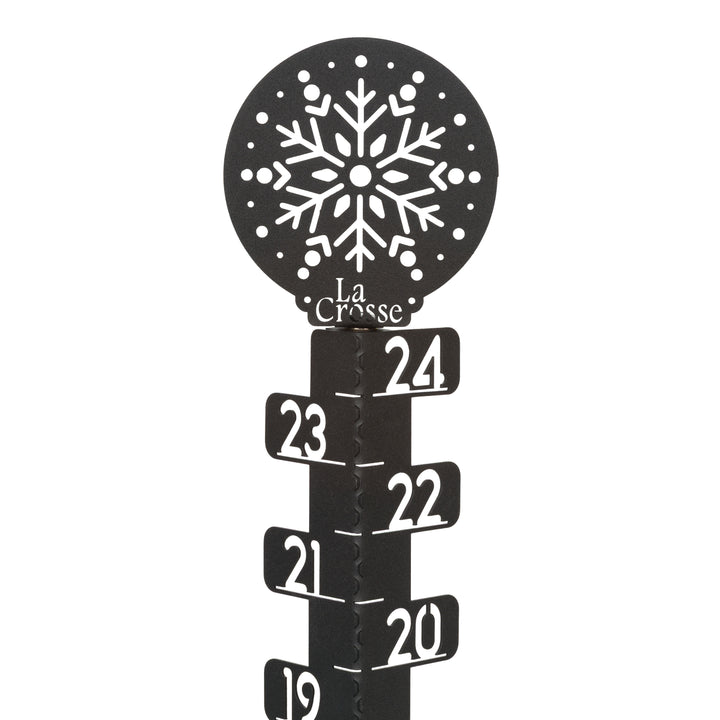 Detail view of the ornamental snowflake accent at the top of the 139-4686 metal snow gauge showing the La Corsse logo and inch measurement markings laser cut in the metal