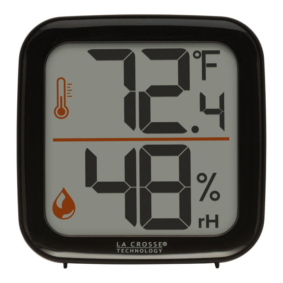 Head-on image of the 302-1407B Thermometer with Temperature and Humidity - Black. The thermometer features a black square case and a digital screen with large temperature and humidity readings. Next to the digits are corresponding temperature and humidity icons in orange.