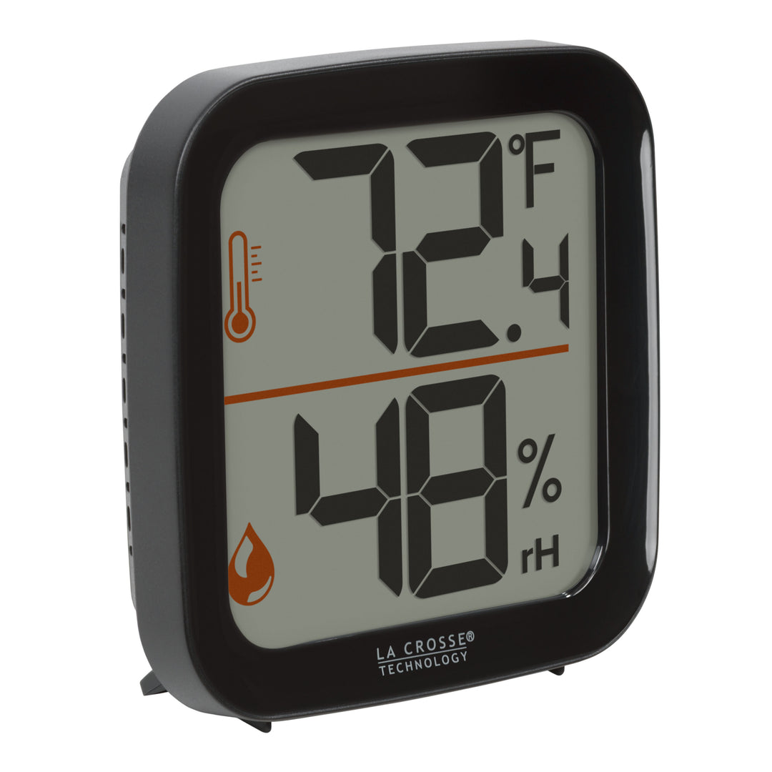 Right-facing image of the 302-1407B Thermometer with Temperature and Humidity - Black. The thermometer features a black square case and a digital screen with large temperature and humidity readings. Next to the digits are corresponding temperature and humidity icons in orange.