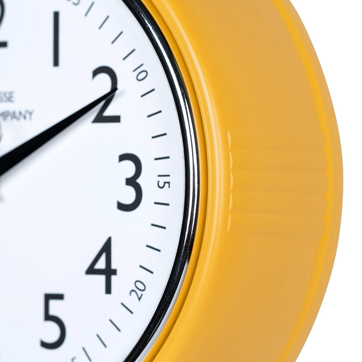 Close-up frame image of the 404-3024MY 9.5-inch Diner Clock – Mustard Yellow, features a retro-style mustard yellow frame with a white dial, chrome bezel, black numbers and minute markings, black metal hour and minute hands, and a silver second hand.