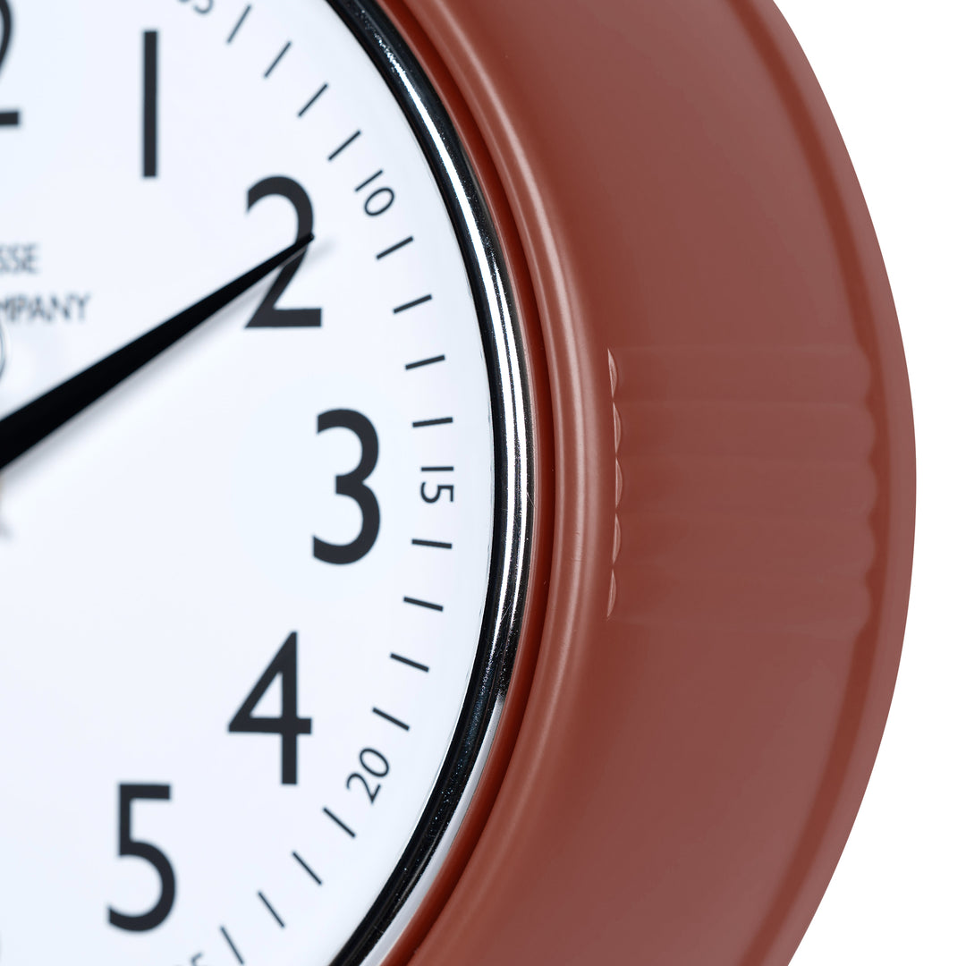Close-up frame image of the 404-3024TC 9.5-inch Diner Clock – Terracotta features a retro-style terracotta frame with a white dial, chrome bezel, black numbers and minute markings, black metal hands, and a silver second hand.