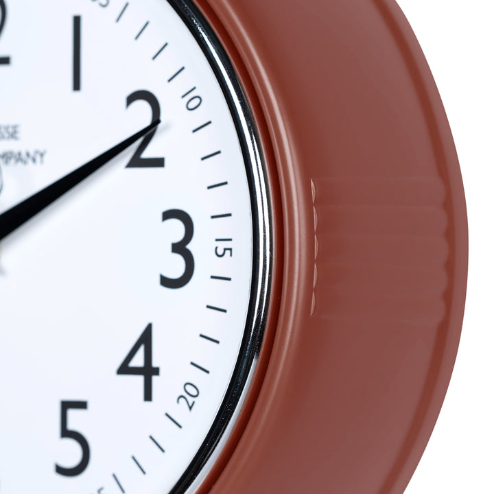 Close-up frame image of the 404-3024TC 9.5-inch Diner Clock – Terracotta features a retro-style terracotta frame with a white dial, chrome bezel, black numbers and minute markings, black metal hands, and a silver second hand.
