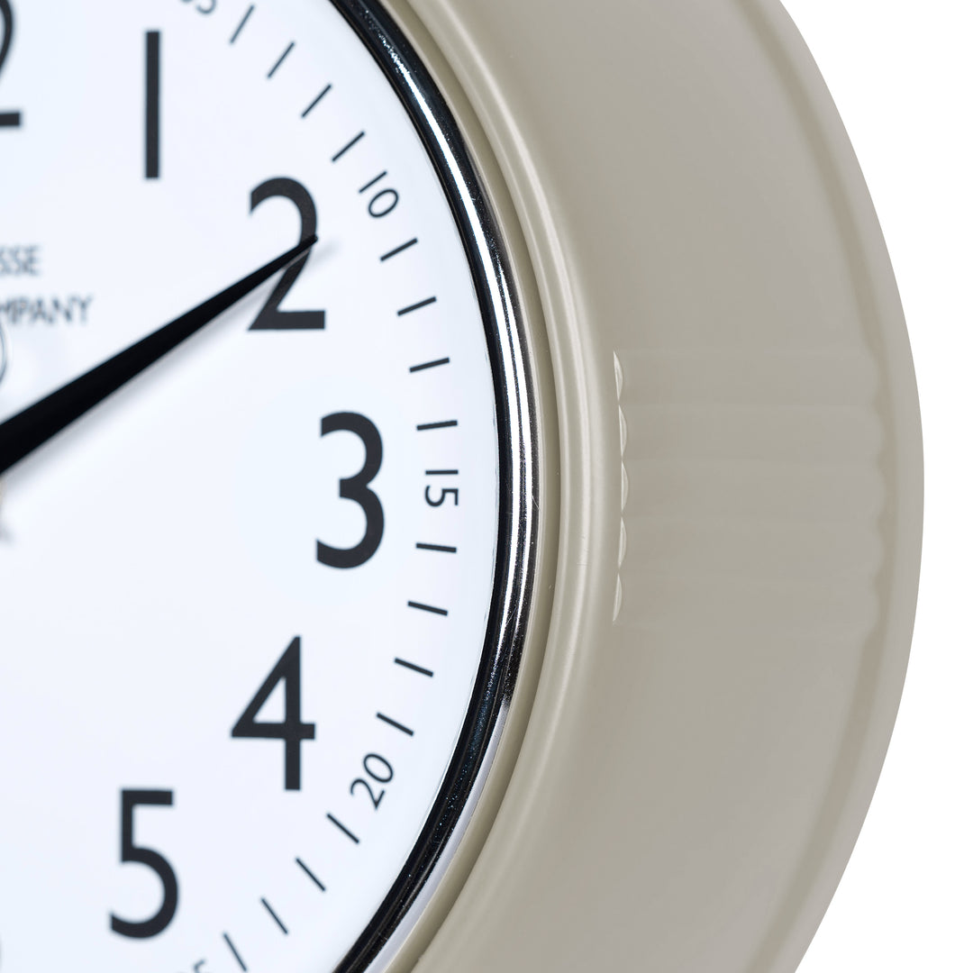 Close-up frame image of the 404-3024TP 9.5-inch Diner Clock – Taupe, features a retro-style taupe frame with a white dial, chrome bezel, black numbers and minute markings, black metal hands, and a silver second hand.