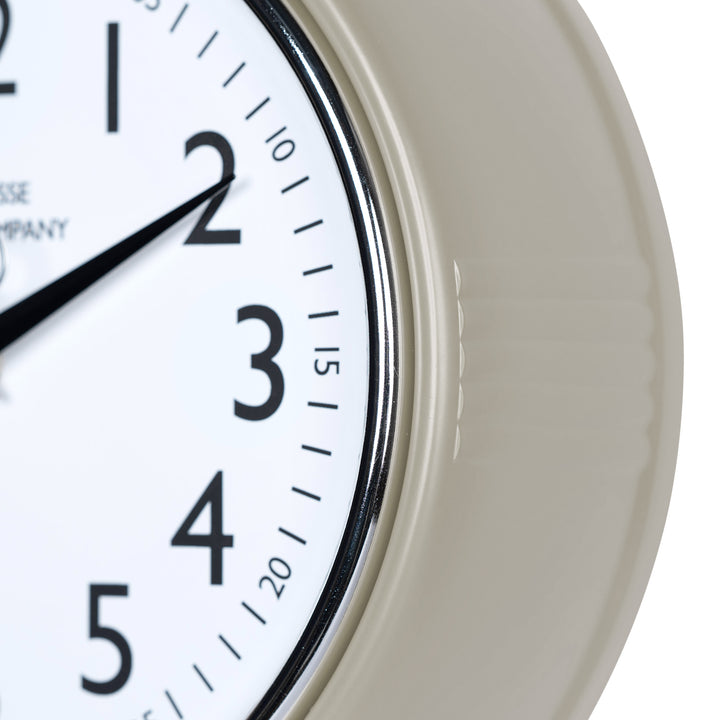 Close-up frame image of the 404-3024TP 9.5-inch Diner Clock – Taupe, features a retro-style taupe frame with a white dial, chrome bezel, black numbers and minute markings, black metal hands, and a silver second hand.