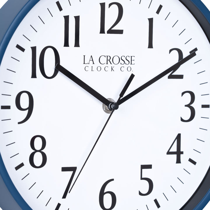 Close-up image of the dial of the 404-3025NB 10-inch Basic Decor Wall Clock with a Navy Blue frame, white dial with black numbers, hour, and minute hands, and a black second hand