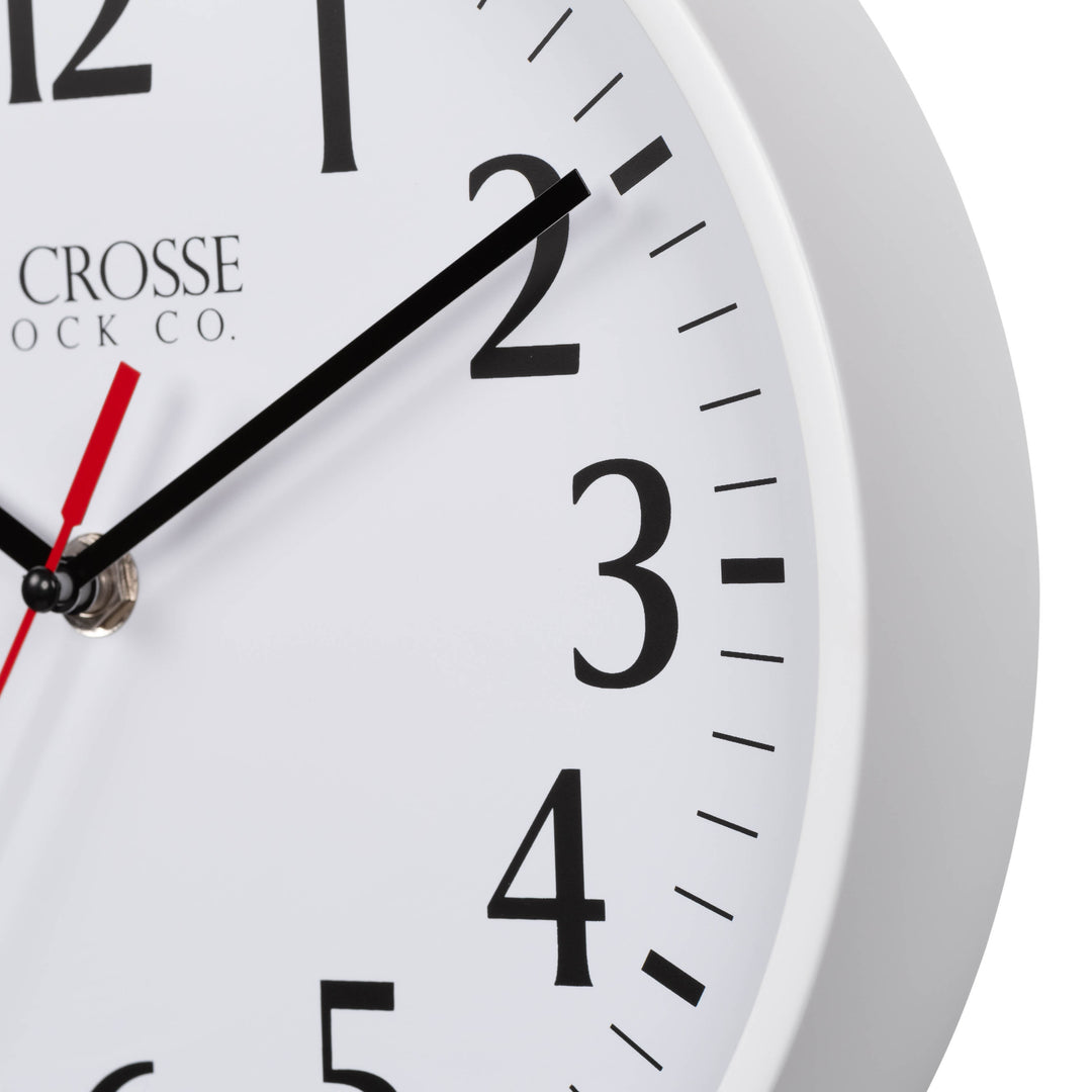 Close-up image of the White frame of the 404-3025W 10-inch Basic Decor Wall Clock with a white dial, black numbers, hour, minute hands, and a red second hand