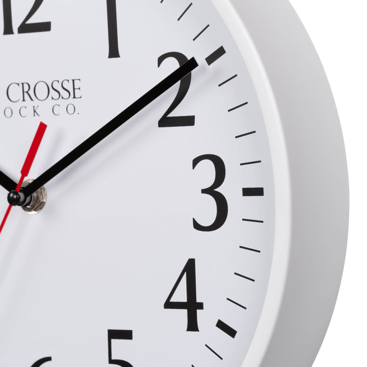 Close-up image of the White frame of the 404-3025W 10-inch Basic Decor Wall Clock with a white dial, black numbers, hour, minute hands, and a red second hand