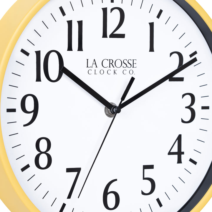Close-up image of the dial of the 404-3025Y 10-inch Basic Decor Wall Clock with a yellow frame,  white dial, black numbers, hour, minute, and second hands.