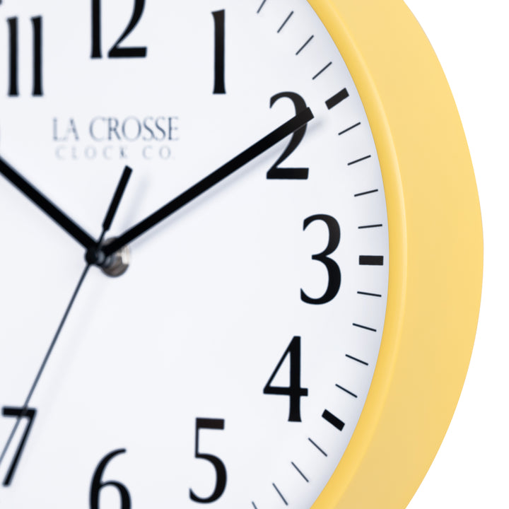 Close-up image of the Yellow frame of the 404-3025Y 10-inch Basic Decor Wall Clock with a white dial, black numbers, hour, minute, and second hands.