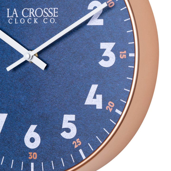 Close up image of the 404-3027C Portside wall clock showing the copper frame and navy blue dial with white numbers, orange minute markings, and white hands