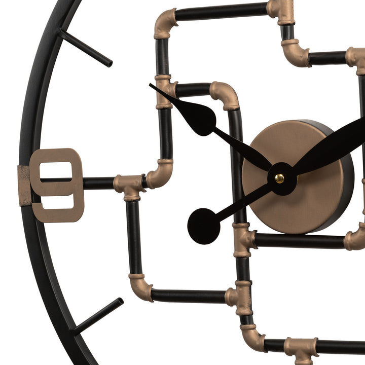 Close-up detail of the pipe framework of the 404-3420 20-inch Pipeworks Metal Wall Clock featuring an open face dial with a weathered bronze and antique brass finish pipe framework, black decorative metal hour and minute hands, and antique brass numbers at 3, 6, 9, and 12.
