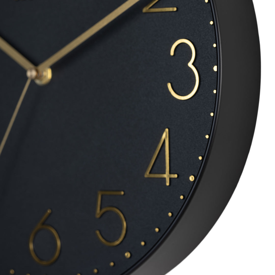 Close-up image highlighting the frame of the 404-3831B 12-inch Paxton Wall Clock - Black, with Silent Sweep, featuring a flush-mount black frame, a matching color dial, brass raised numbers, and brass-finished hour, minute, and second hands.