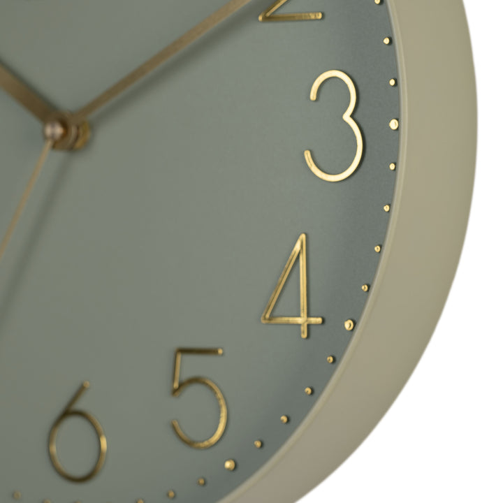 Close-up image highlighting the frame of the 404-3831G 12-inch Paxton Wall Clock - Green, with Silent Sweep, featuring a flush-mount green frame, a matching color dial, brass raised numbers, and brass-finished hour, minute, and second hands.