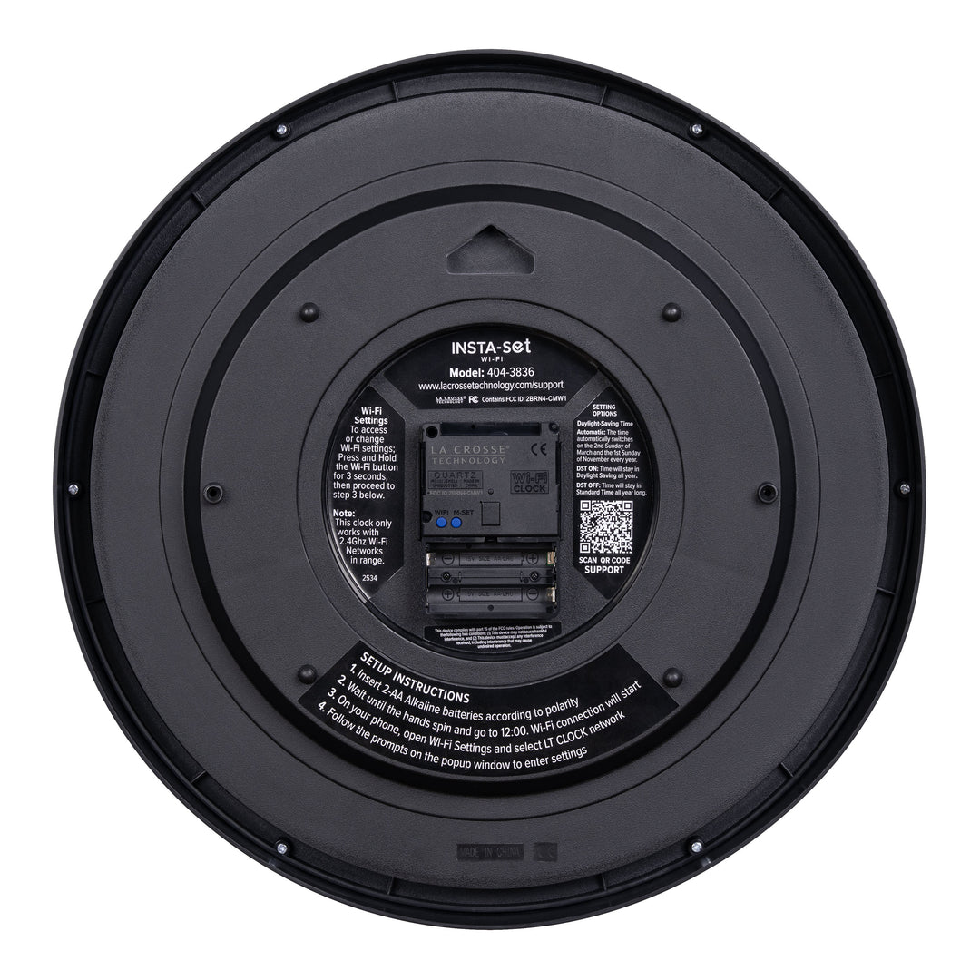Back view showing the battery compartment with instructions and a QR code of the 404-3836 Insta-Set Wi-Fi Analog Wall Clock in black plastic and white text