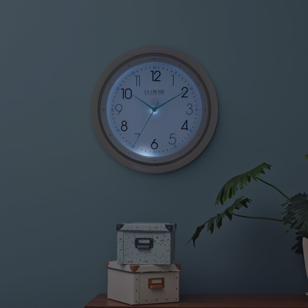 404-4525 glow in the dark wall clock night lifestyle scene with the clock lit up in the dark detailing its blue nighttime glow