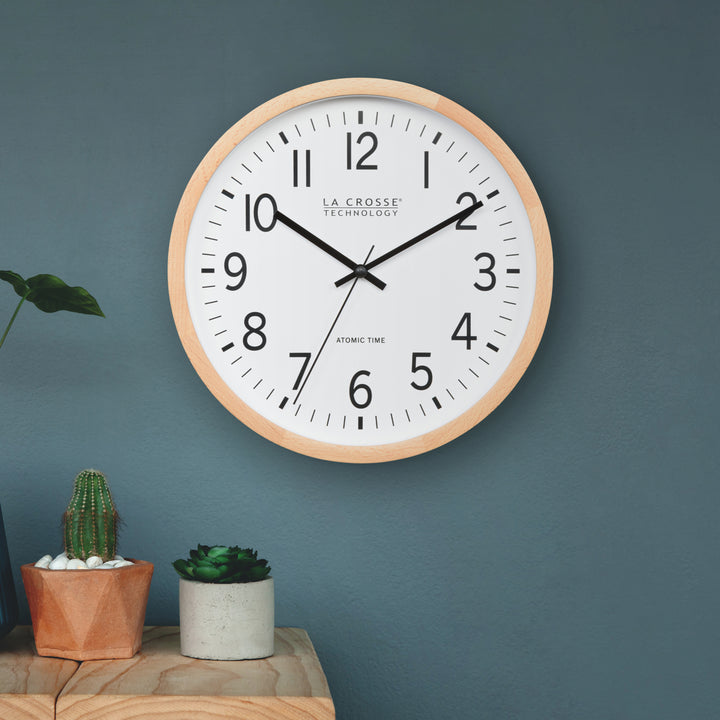 Wall clock with wooden frame on a blue wall, featuring &