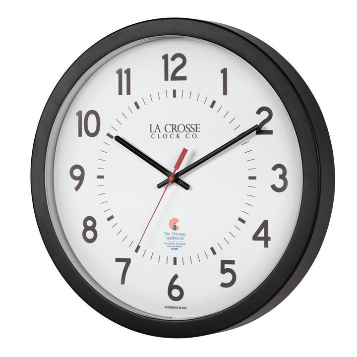 Left-facing image of the 404-5537 14.5-inch Wall Clock with black bold numbers, black hour and minute hands, and a red second hand. Two logos apear on the clock, 
La Crosse Clock Co. and Chicago Lighthouse industries - a partner that employs the blind to bring this classic wall clock to consumers.