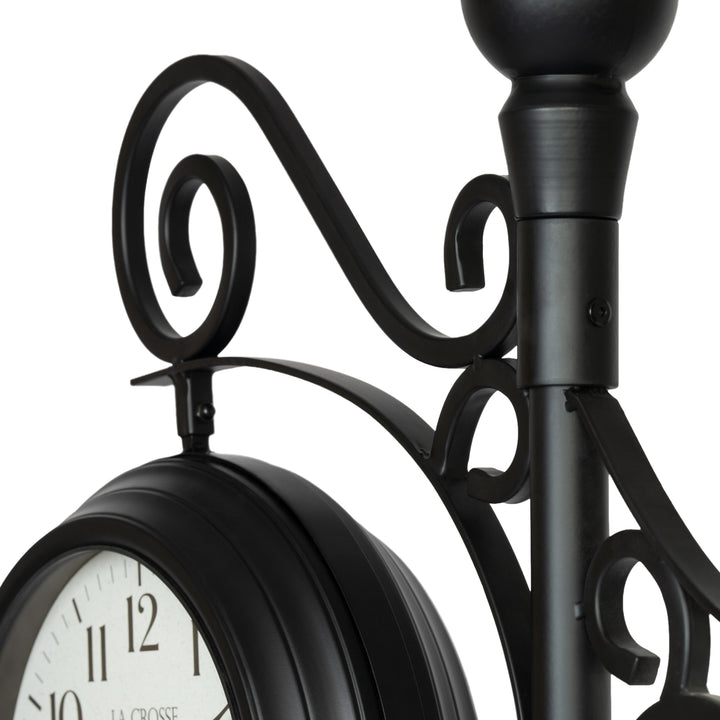 Close-up detail image of the 425-34188 Outdoor Dual-Sided Metal Pedestal Clock showing the scroll work and how the clocks are attached.