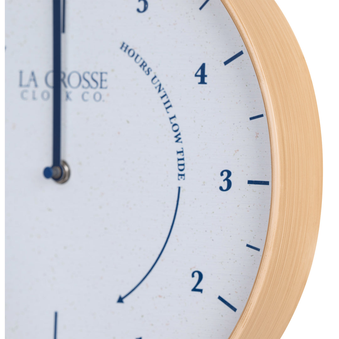 Close-up image of the natural wood frame detail of the 425-3831 11.8-inch Tide Wall Clock. The clock features a light wood frame, a white and tan speckled dial, blue numbers, markings, and a blue metal hand.