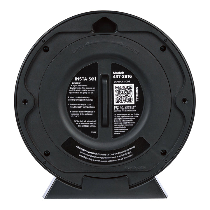 Head-on back image of the 437-3816 Insta-Set Table/Wall Clock with Bluetooth® Technology showing  the back of the clock with the battery cover on and the instructions printed on the back with a support QR code.