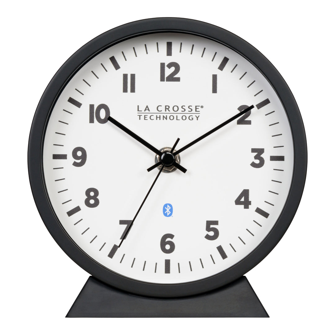 Head-on image of the 437-3816 Insta-Set Table/Wall Clock with Bluetooth® Technology featuring a white dial with bold black numerals, black metal hands, and a black frame with removable base for tabletop or wall hanging placement.