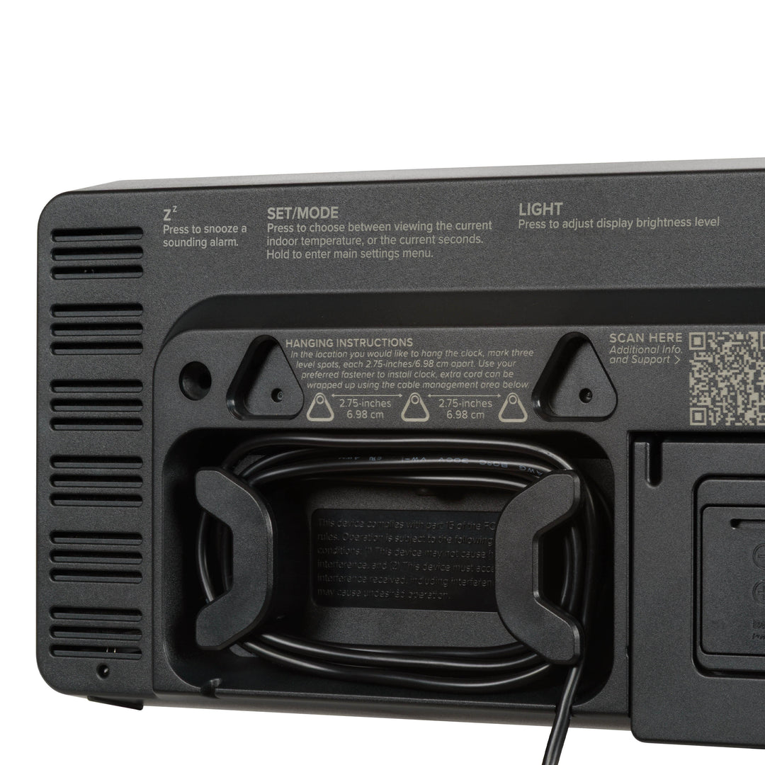 Close-up image of the cable management system of the 513-1411R Digital LED Wall Clock with Indoor Temperature. The back of the clock also shows two of the three hanging holes and a hint of the fold-out kickstand for placement.