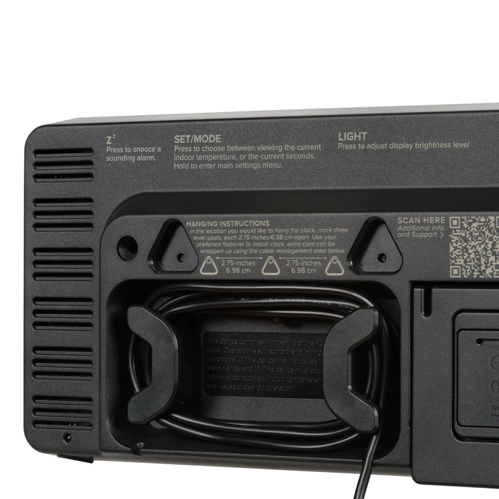 Close-up image of the cable management system of the 513-1411R Digital LED Wall Clock with Indoor Temperature. The back of the clock also shows two of the three hanging holes and a hint of the fold-out kickstand for placement.