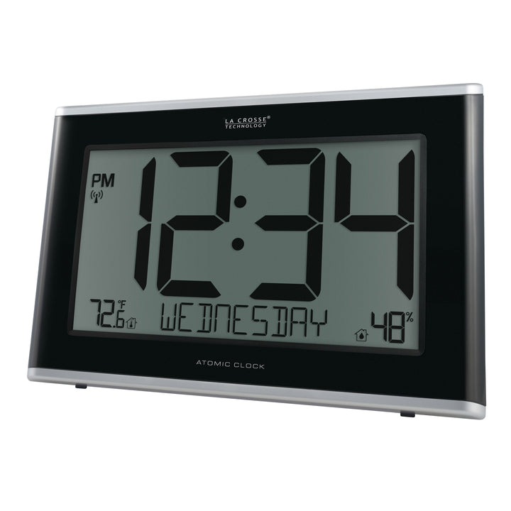 Angeld left-facing image of the 513-36908 Executive Atomic Digital Wall Clock with Temperature and Humidity features a black frame, a large LCD screen displaying 12:34 pm, Wednesday, indoor temperature, humidity, and signal icons.