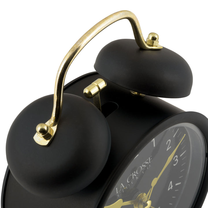 Detail shot of the twin bells of the 617-3314BG Metal Twin Bell Alarm Clock – Black, the clock features a black dial with white numbers, gold hands and accents, in a black metal case.