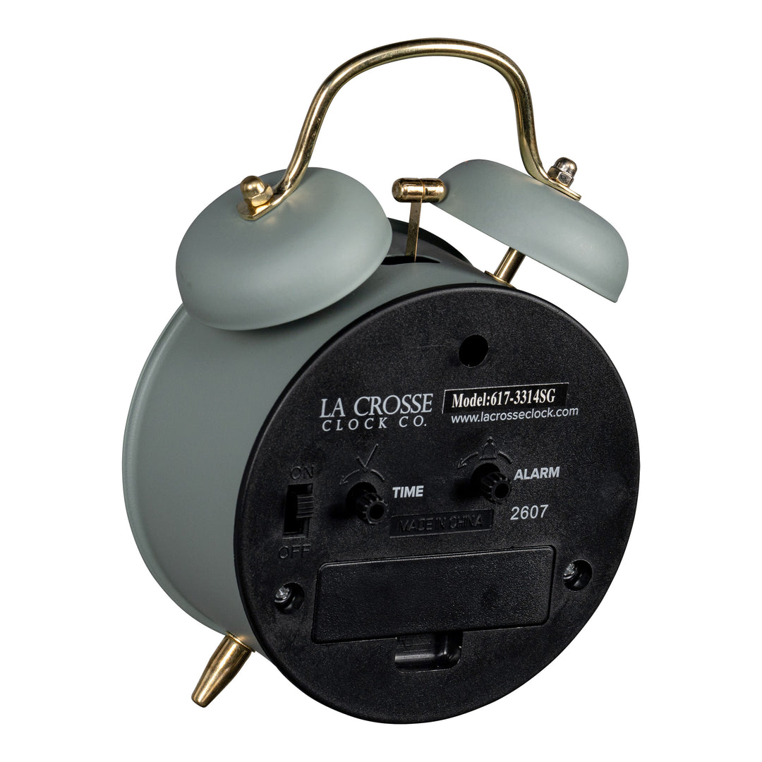 Angled back image of the 617-3314SG Metal Twin Bell Alarm Clock – Sage Green, showing the battery compartment, knobs, and the on/off switch.