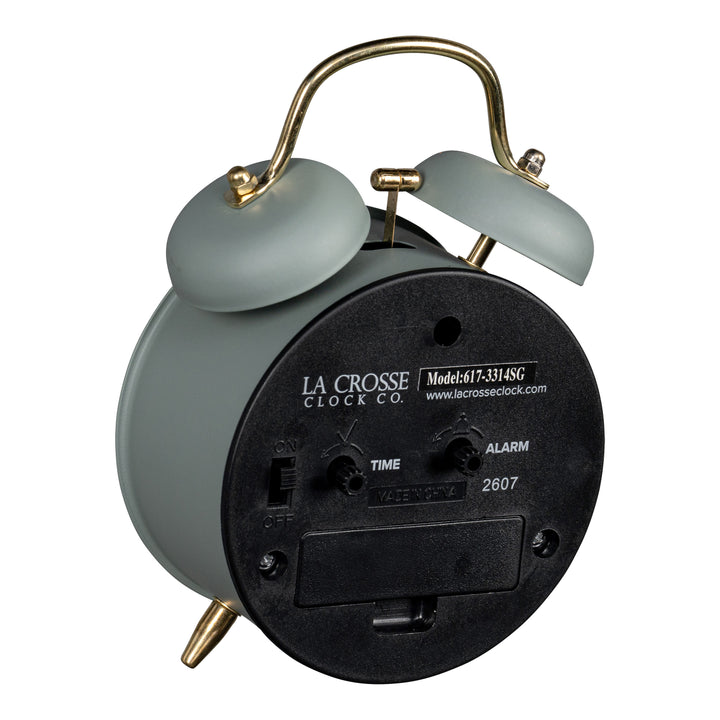 Angled back image of the 617-3314SG Metal Twin Bell Alarm Clock – Sage Green, showing the battery compartment, knobs, and the on/off switch.