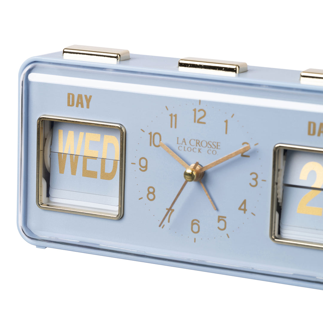 Angled close-up image of the 636-379BL Daily Flip Tabletop Clock with Calendar – Blue, featuring a retro design rectangular analog clock with brass numbers, hour, minute, and second hands, and a day and date calendar with manual flip cards with brass text.
