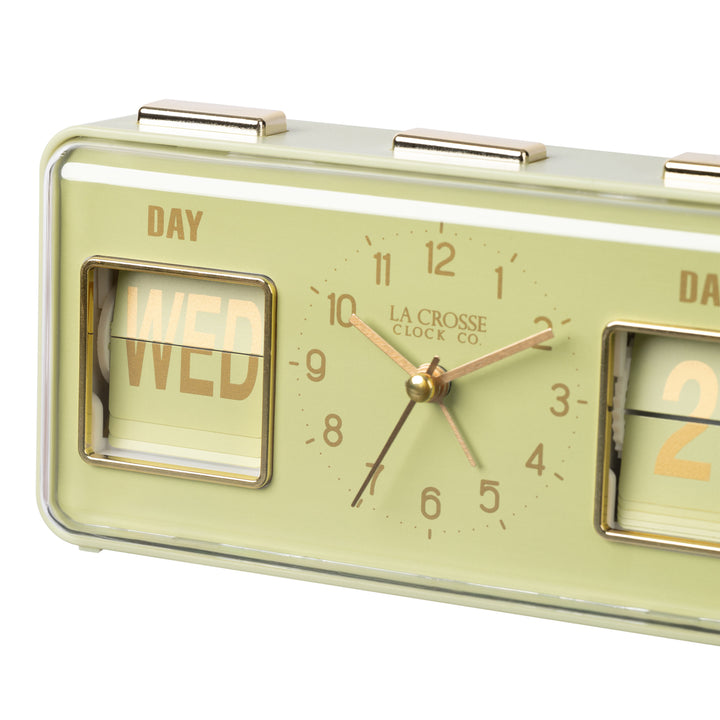 Angled close-up image of the 636-379G Daily Flip Tabletop Clock with Calendar – Green, featuring a retro design rectangular analog clock with brass numbers, hour, minute, and second hands, and a day and date calendar with manual flip cards with brass text.