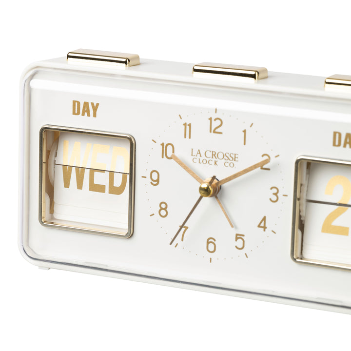 Angled close-up image of the 636-379W Daily Flip Tabletop Clock with Calendar – White, featuring a retro design rectangular analog clock with brass numbers, hour, minute, and second hands, and a day and date calendar with manual flip cards with brass text.