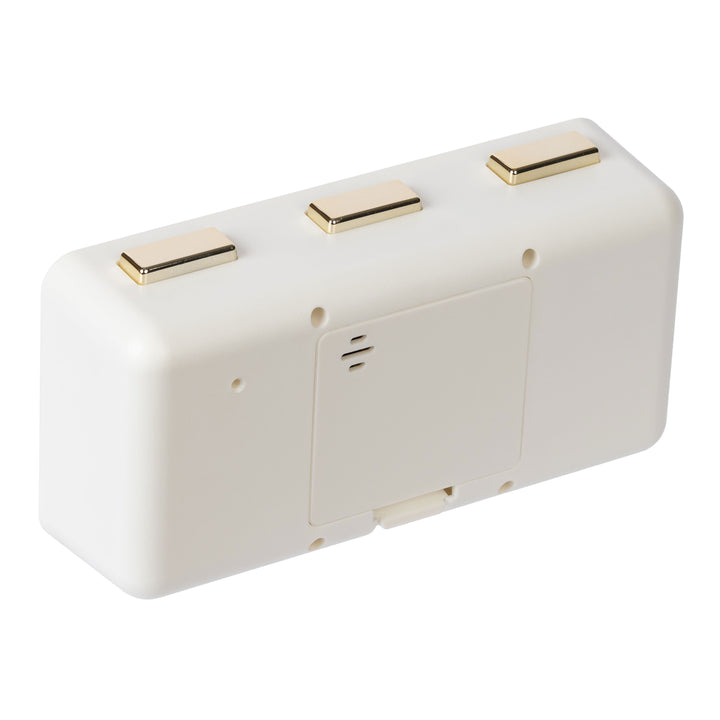 Angled back image of the 636-379W Daily Flip Tabletop Clock with Calendar – White, showing the battery compartment with the cover in place, and the three brass buttons to operate the calendar and the alarm.