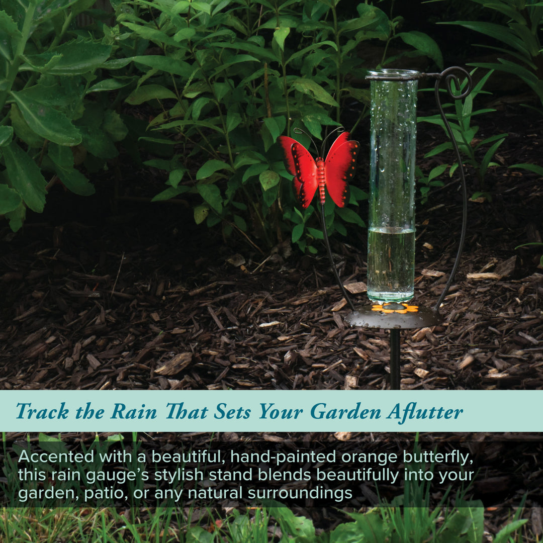 704-13077 Rain gauge with a hand-painted orange butterfly in a garden setting