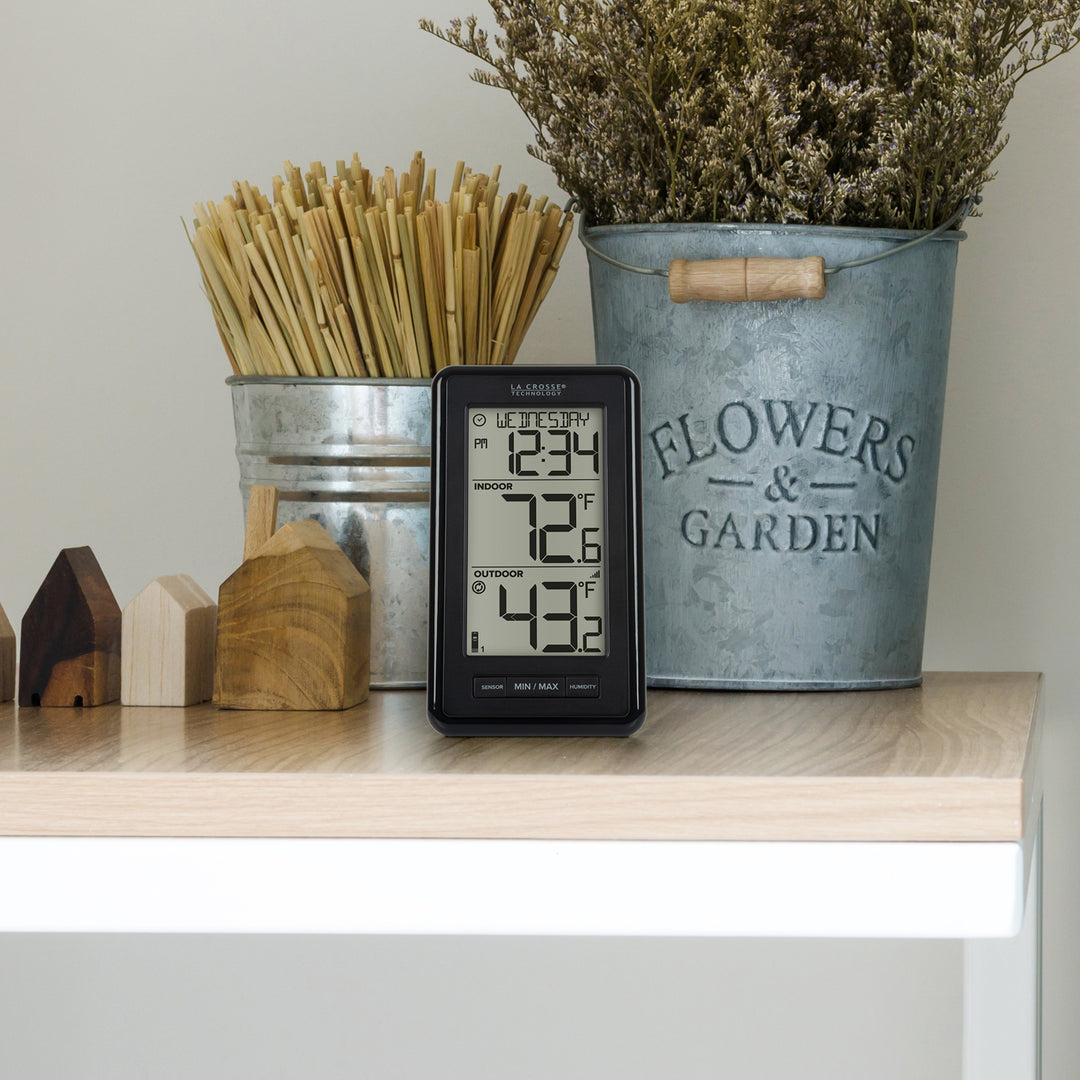 ws-9160 Digital thermometer on a shelf with decorative items including a metal bucket labeled &